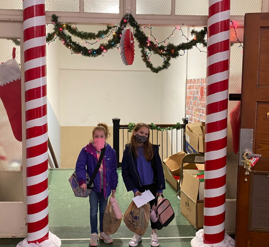 two girls with bags inside candy cane poles